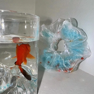 Chouchou en organza bleu dégradé avec perles à côté d'un bocal de poisson rouge