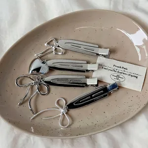 Set di fermagli per capelli in metallo argento con cuori e fiocchi su vassoio