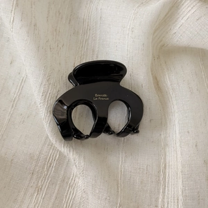 Close-up of elegant black acetate hair claw with golden Barrette La France lettering