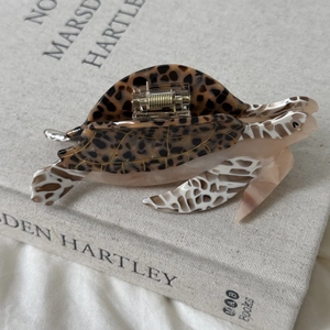 Pince à cheveux élégante en acétate en forme de tortue de mer sur un livre