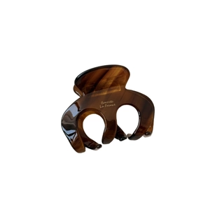 Elegant amber tortoiseshell acetate hair claw clip with glossy finish on white background