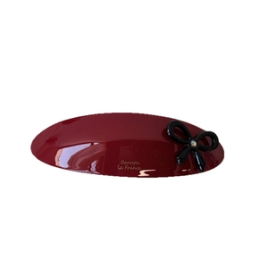 Elegant deep red oval acetate hair clip with black bow and gold lettering