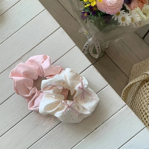 Close-up of pink and polka dot scrunchies with ribbon bows and faux pearls