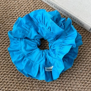 Détail du chouchou plissé bleu roi montrant la texture riche du tissu et les bords cousus