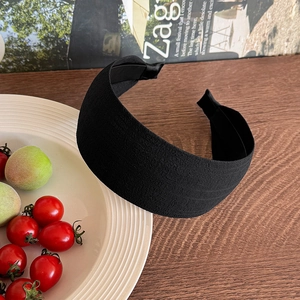 Close-up of matte black wide headband featuring a textured fabric and non-slip inner teeth