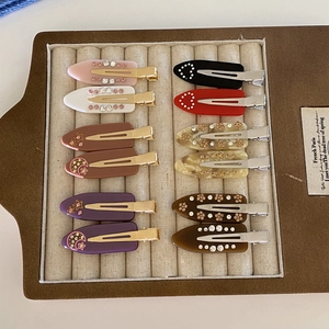 French style acetate hair clips set with rhinestones and geometric patterns on a tray