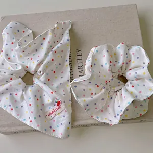 Ensemble de chouchous en tissu à pois arc-en-ciel avec ruban sur un livre
