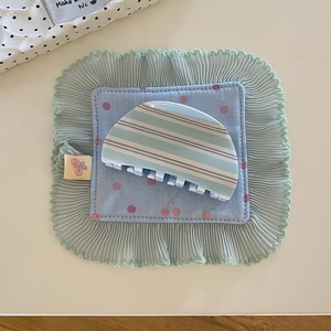 Détail de la pince à cheveux à rayures bleues sur tissu au design chic 2025
