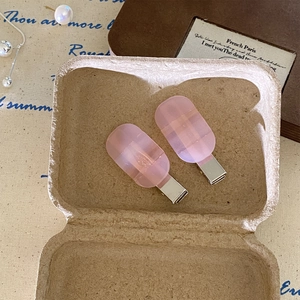Pair of Korean minimalist pink acetate hair clips on vintage fabric background display