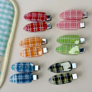 Detail view of 12-piece acrylic checkered hair clips with sparkling gold glitter accents
