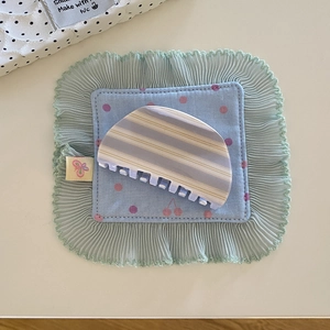 Détail macro d'une pince à cheveux à rayures bleu et beige avec dents en plastique