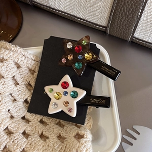 Star-shaped duckbill hair clips with colorful rhinestones in brown and cream finishes