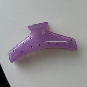 Detailed close-up of lavender translucent hair claw clip with embedded white rhinestones