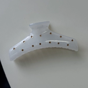 Detailed view of translucent resin hair claw clip with amber rhinestones and metal spring
