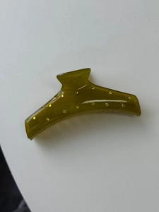 Detail of amber green resin hair claw clip featuring yellow rhinestones and spring