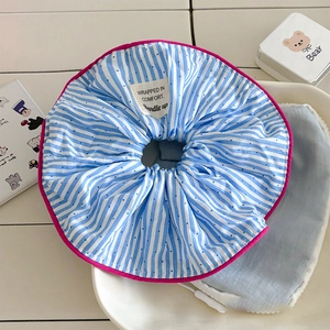 Détail d'un chouchou à rayures bleues avec bords roses et étiquette en tissu décorative