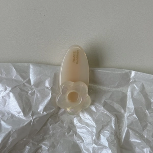 Détail d'une pince à cheveux fleurie crème avec lettrage France Handmade doré et poli