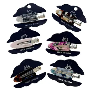 Lot de six barrettes en acétate colorées aux motifs léopard et floraux sur support