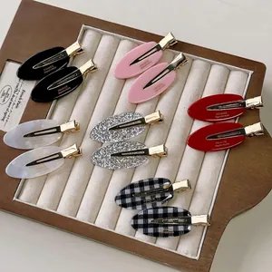 Set of minimalist oval acetate hair clips in assorted colors on a jewelry display tray