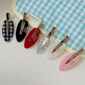 Set of six oval acetate hair clips in assorted patterns with golden metal alligator base