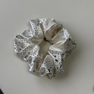 Détail d'un chouchou en velours crème avec cristaux et strass brillants de luxe