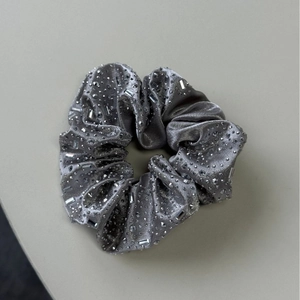 Détail d'un chouchou de luxe en velours argenté avec strass et pierres de cristal