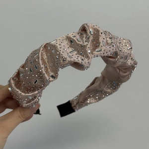 Détail d'un chouchou en velours avec des strass étincelants et un tissu plissé élégant