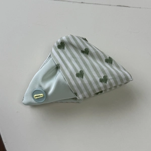 Dettaglio di accessorio in tessuto verde menta con strisce e stampe a cuore