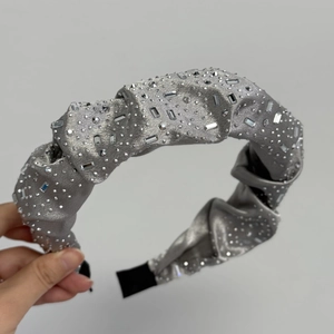 Détail du serre-tête en soie grise serti de strass argentés avec embouts de protection noirs