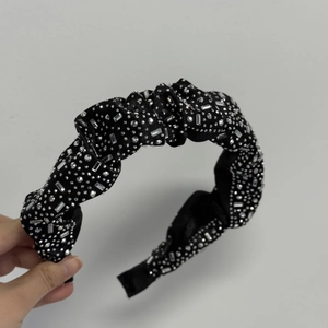 Détail d'un chouchou en velours noir avec des strass étincelants et finitions en cristal