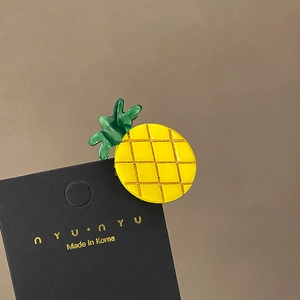 Detail view of yellow pineapple fruit hair claw clip with golden grid texture