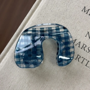 Dettaglio della molletta per capelli a quadretti blu con bordi in acrilico trasparente