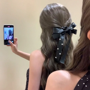 Elegant black satin bow hair tie with silver star patterns for long ponytail styling