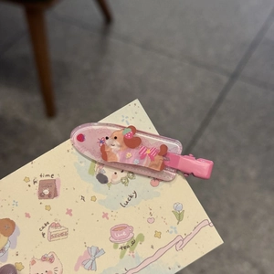 Primo piano di fermaglio per capelli a cartone animato con cane, fragola e fiori rosa