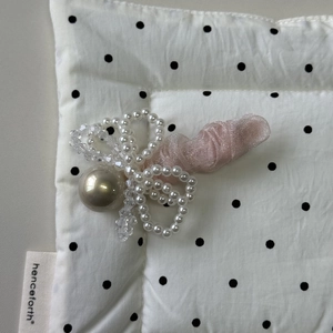 Détail de la pince à cheveux noeud en tulle rose avec perle champagne et cristaux