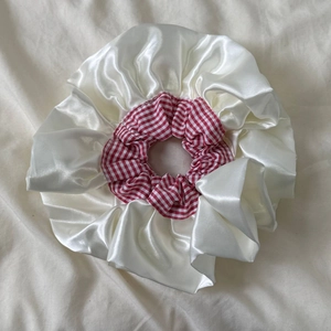 Détail d'un chouchou à carreaux rouges et blancs avec des finitions en satin crème doux
