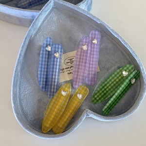 Set mit 8 Herz-Haarspangen mit Strass und Pastell-Karo-Muster auf einem blauen Tablett