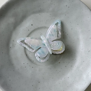 Iridescent acetate butterfly hair clip with blue and pink marble texture and gold metal grip
