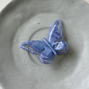 Macro detail of lavender iridescent acetate butterfly hair clip with pearlescent texture
