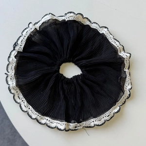 Elegant black pleated scrunchie with white lace trim for sophisticated hair styling