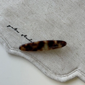 Detail of tortoise shell hair clip featuring France Handmade gold engraving on fabric