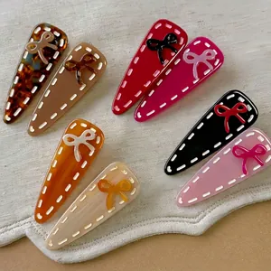 Lot de 7 barrettes à cheveux mates avec nœud 3D sur un tissu texturé beige