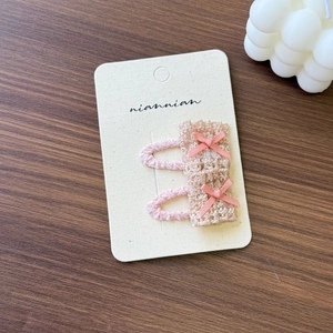 Close-up of pink and beige lace flower hair clips with delicate ribbon bows