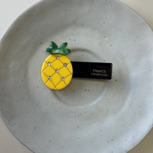 Detailed view of yellow pineapple hair clip with sparkling rhinestones and handmade engraving