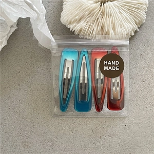 Detailed set of four drip oil teardrop hair clips in premium handmade zipper bag