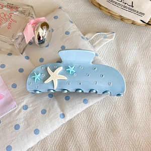 Détail de la pince à cheveux étoile de mer bleu clair avec strass pour style marin