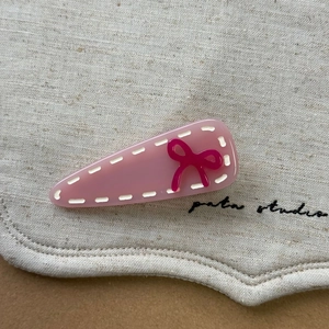 Barrette à cheveux rose douce en forme de goutte avec un nœud en résine sur lin naturel