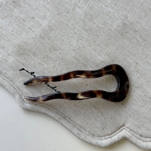 Close-up of tortoise shell pattern acetate U-shaped hair pin on linen fabric