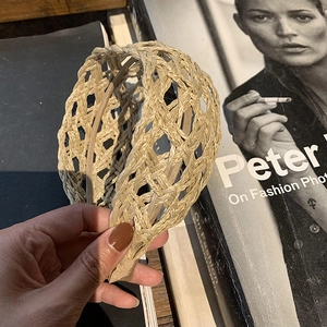 Handcrafted hollow raffia woven headband with natural straw texture in minimalist style