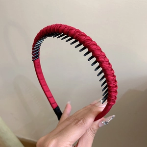Detail of red braided headband featuring black anti-slip inner teeth for secure hair styling